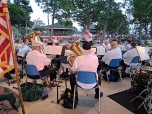 Band members performing at an outdoor summer concert